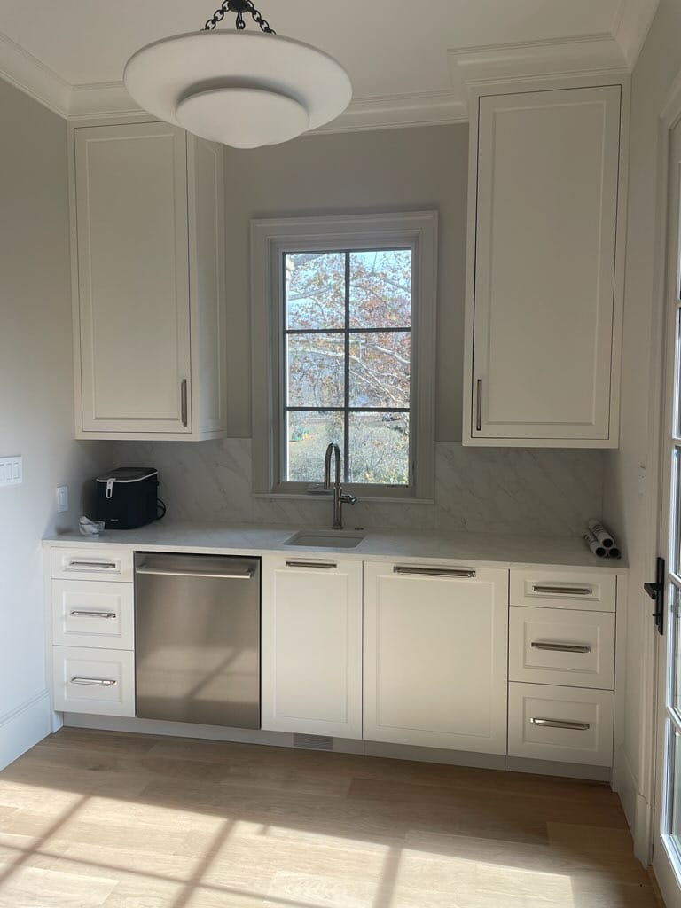 White window-side cabinetry with a sink, dishwasher, drawers, and tall upper cabinets