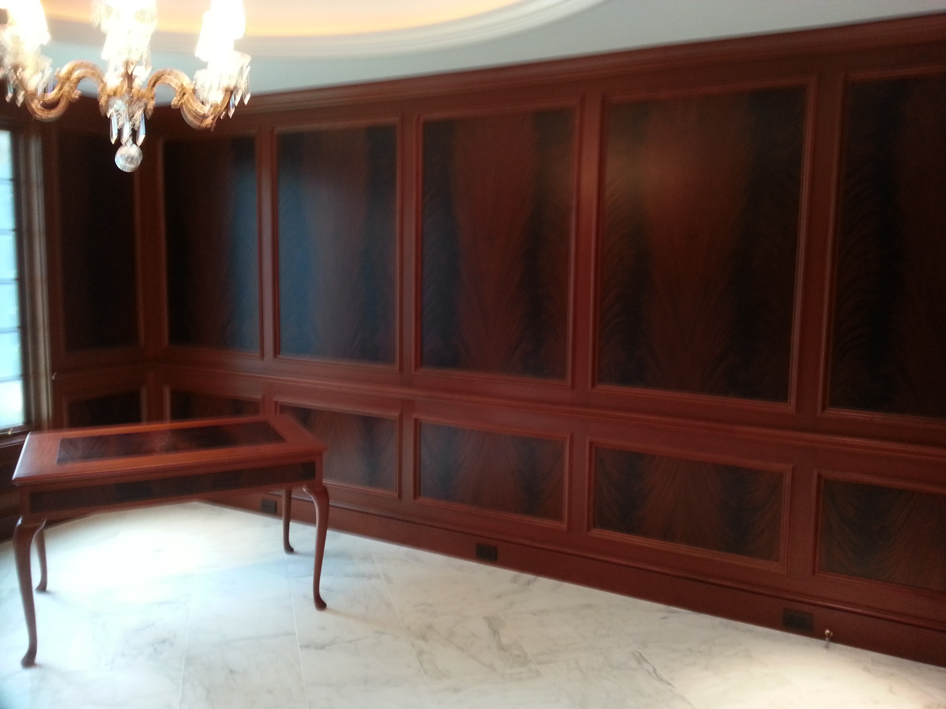 Custom dark wood wall paneling with traditional raised moulding details